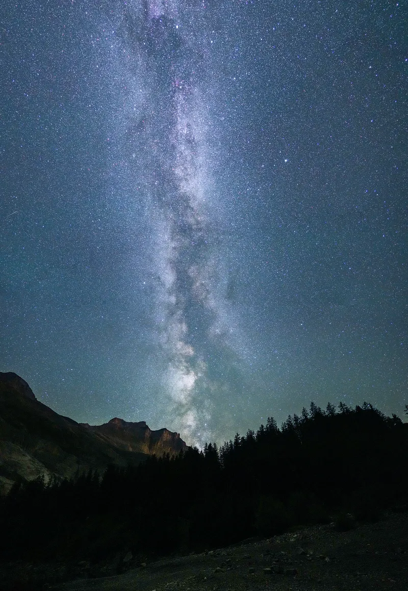 The Milky Way rising over mountains on a dark night.