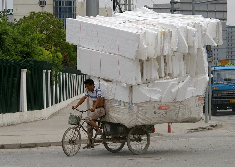A cargo tricycle carrying a huge load through Shanghai.