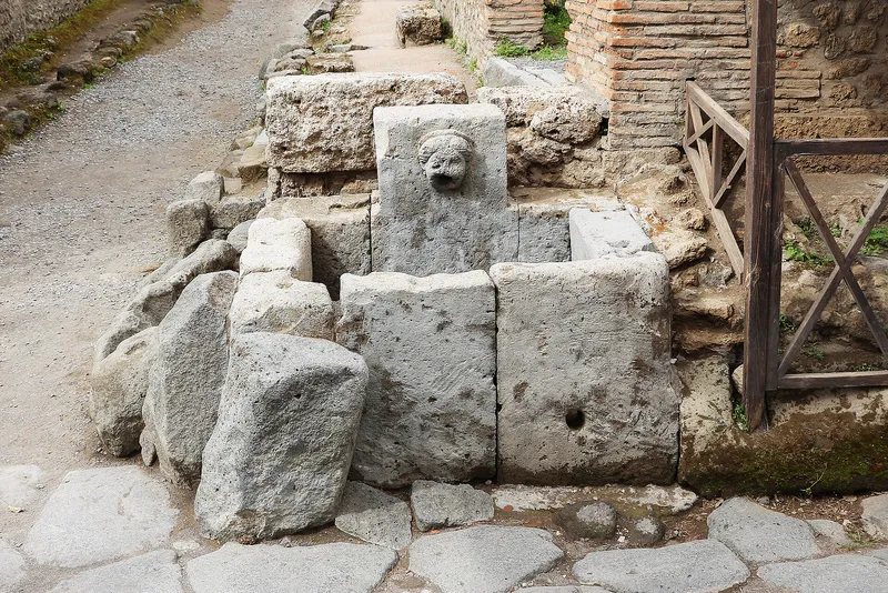 A street fountain in Pompeii: a stone basin with a carved spout.